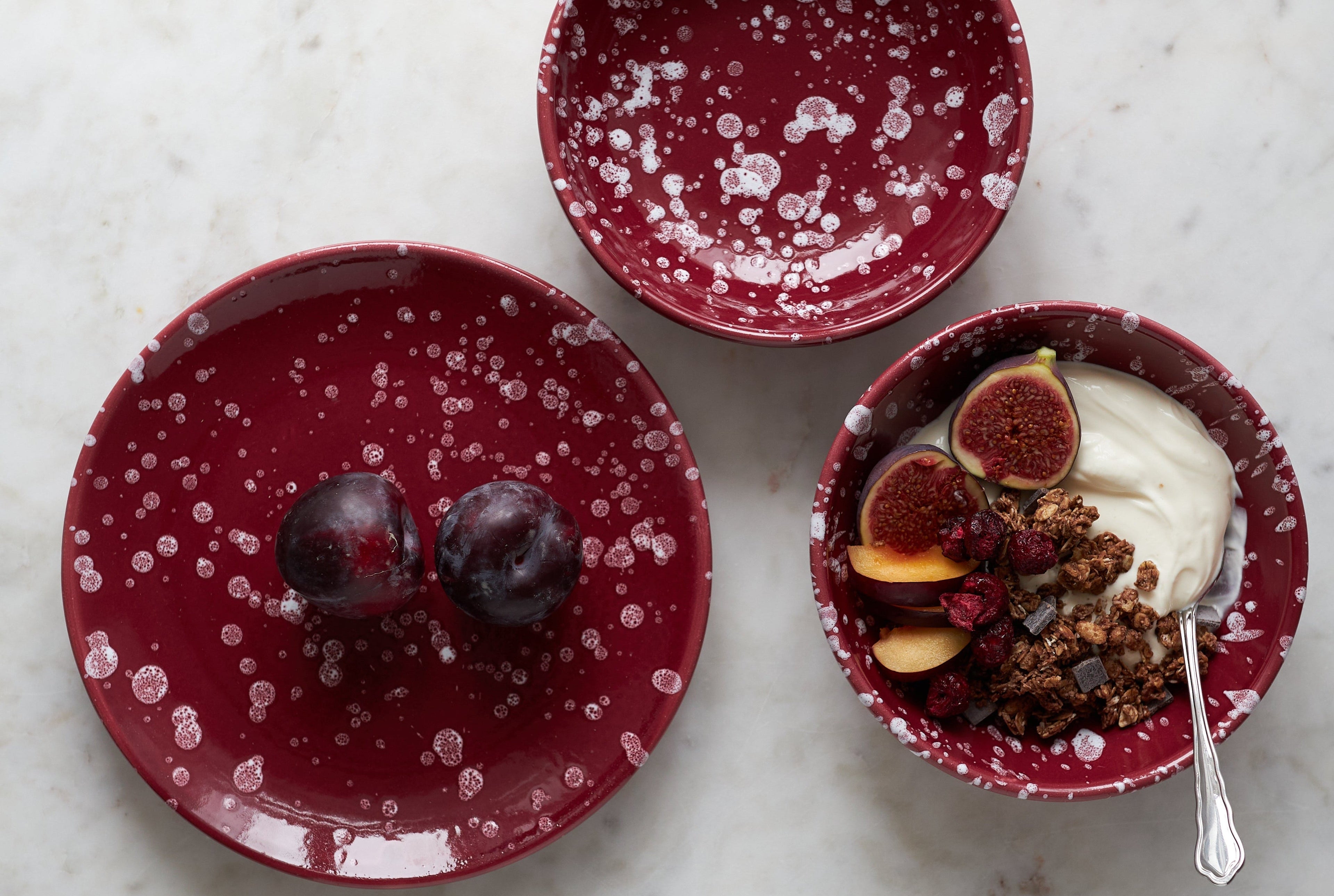Handgemachte italienische Keramik in Burgunderrot mit weißen Farbspritzern.